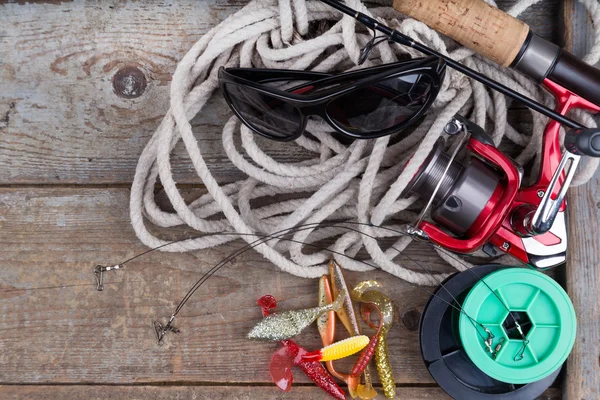 Fishing tackles on wooden board with rope — Stock Photo, Image