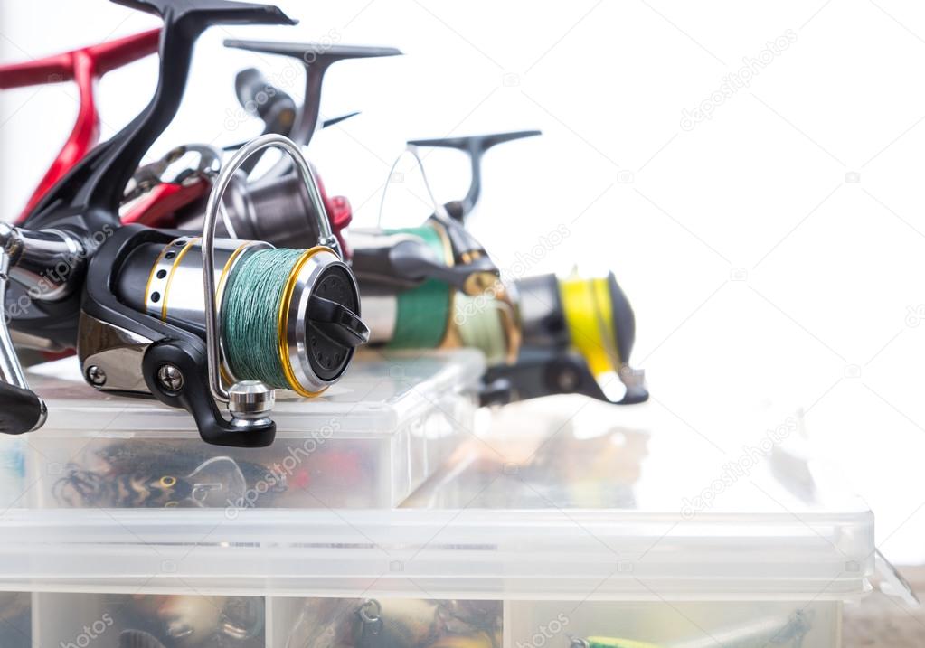 Fishing reels on storage boxes with baits Stock Photo by ©sytnik