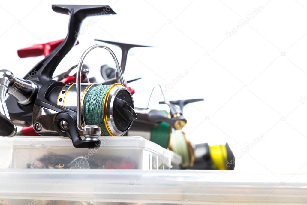 fishing reels on storage boxes with baits
