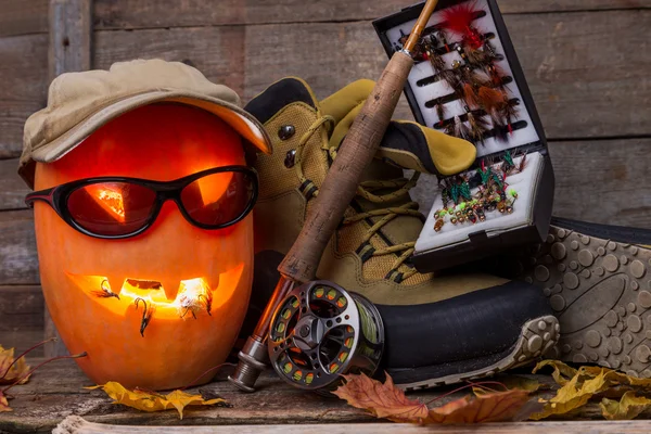 Хэллоуинская тыква в сапогах и на рыбалке — стоковое фото