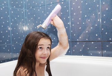 little girl holding a bottle of shampoo clipart