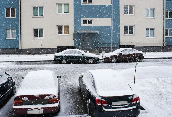 雪の中で家の近くの 4 台の車 — ストック写真