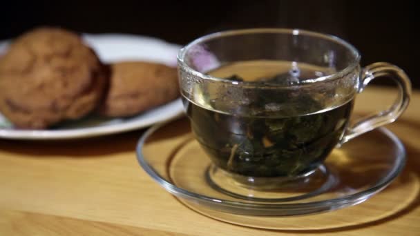 Taza de vidrio con té y galletas en un plato — Vídeos de Stock