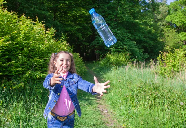 Menina pegar uma garrafa de plástico — Fotografia de Stock