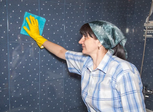 Junge lächelnde Frau wäscht eine Fliese — Stockfoto