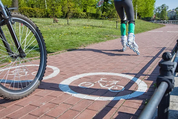 Dziewczyna na rolkach i cyklistą na ścieżce rowerowej — Zdjęcie stockowe