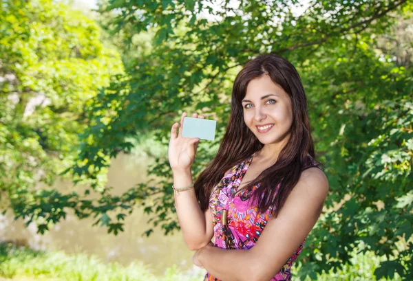 Девушка с кредитной картой в парке — стоковое фото
