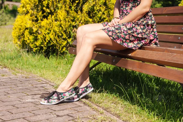 Femme assise sur un banc de parc — Photo