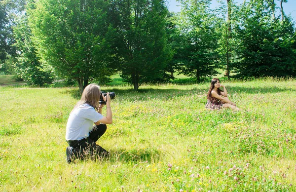 Fotograf má žena sedící na trávě v parku — Stock fotografie
