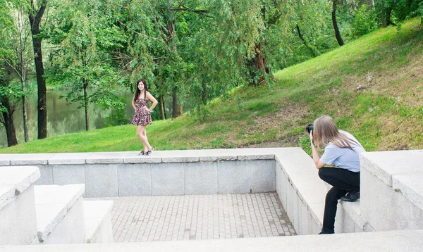 Фотограф берет женщину, стоящую на лестнице в парке — стоковое фото