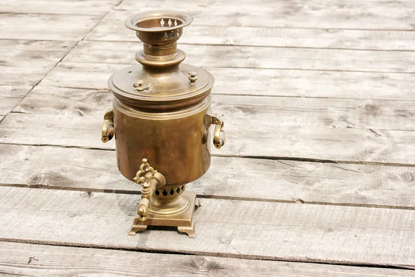 Samovar de bronze em uma mesa de madeira — Fotografia de Stock