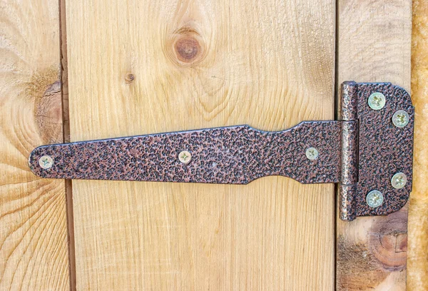 Bisagra metálica en una puerta de madera —  Fotos de Stock