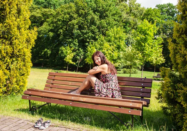 Young girl sitting on a park bench — Stock Photo, Image