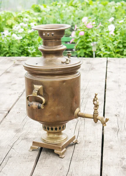 Samovar de bronze em uma mesa de madeira — Fotografia de Stock