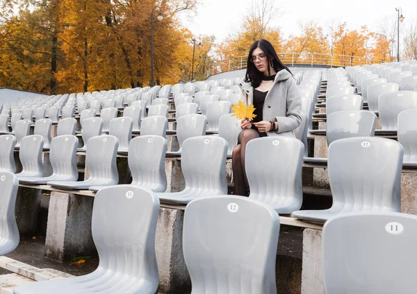 Solitario Giovane Ragazza Cappotto Grigio Seduto Sedile Uno Stadio Vuoto — Foto Stock