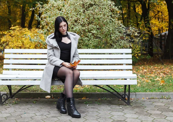 Μοναχικό Νεαρό Κορίτσι Γκρι Παλτό Κάθεται Ένα Παγκάκι Ένα Πάρκο — Φωτογραφία Αρχείου