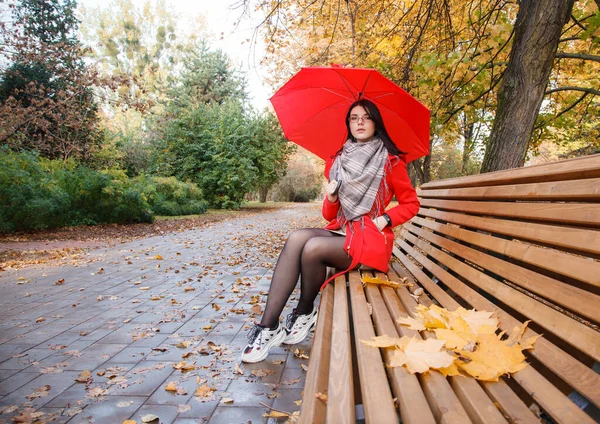 Mladá Dívka Červeném Kabátě Deštníkem Sedí Lavičce Městském Parku Dešti — Stock fotografie