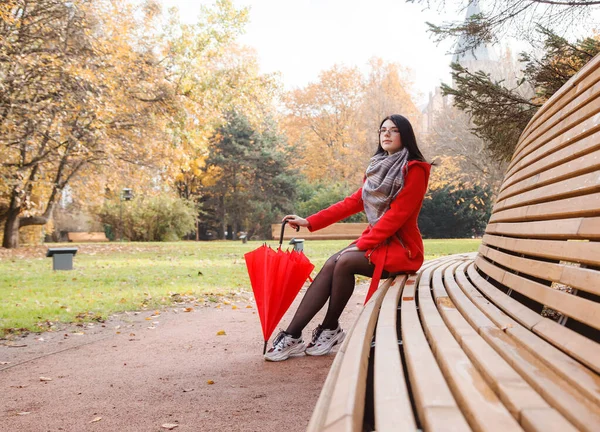 Mladá Dívka Červeném Kabátě Deštníkem Sedí Lavičce Městském Parku Dešti — Stock fotografie