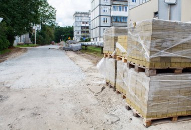 Güneşli bir yaz gününde dışarıda serilmek için hazırlanmış asfalt yığınları.