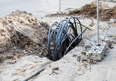 Güneşli yaz gününde şehir caddesinde hendek kablosu