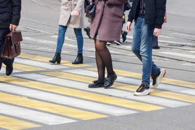 Yayalar bahar günü yaya geçidinde caddeyi geçiyorlar.