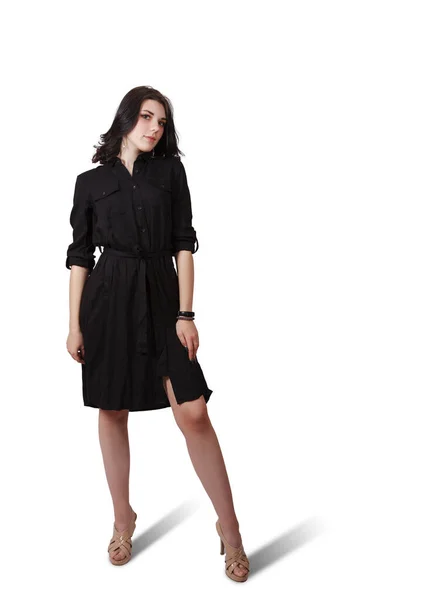 若いですブルネット女性で黒ドレス姿でスタジオに立って上の白い背景 — ストック写真