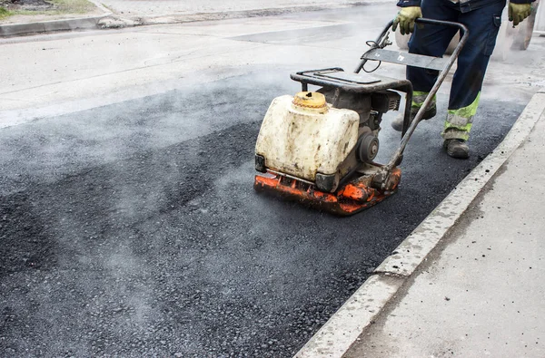 Pracownik Podnosi Asfalt Drodze Mechanicznym Taranem Układanie Nawierzchni Drogi Gorący — Zdjęcie stockowe