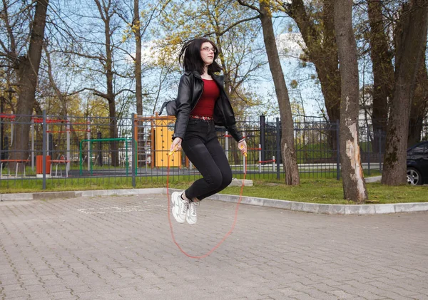 Joven Morena Chica Negro Chaqueta Jeans Saltar Cuerda Aire Libre — Foto de Stock