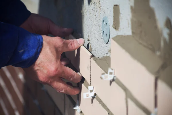 Arbeiter legt Keramikfliesen an die Wand — Stockfoto