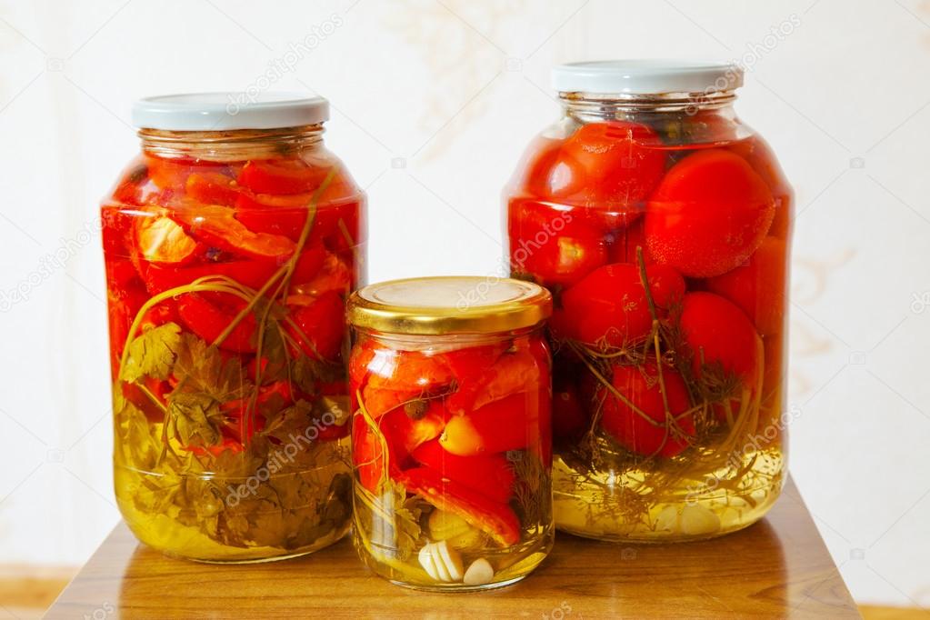 three glass jars with marinated tomatoes homemade