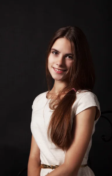 Porträtt av en vacker ung leende flicka i en ljus klänning — Stockfoto