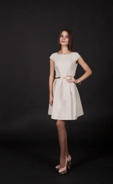 Junge schöne Mädchen in einem hellen Kleid posiert stehend — Stockfoto