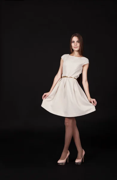 Mooi lachende meisje in een lichte jurk poseren staande — Stockfoto