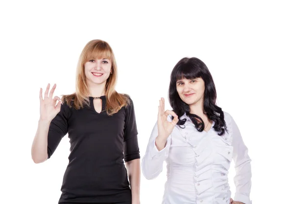 Dos mujeres hermosas jóvenes mostrando signo o 'kay aislado en blanco —  Fotos de Stock