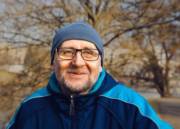 Portrét smějící se starší muž nosí brýle, šedý klobouk — Stock fotografie