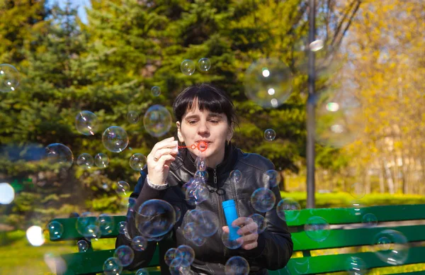 Young beautiful brunette woman blowing bubbles — Stock Photo, Image