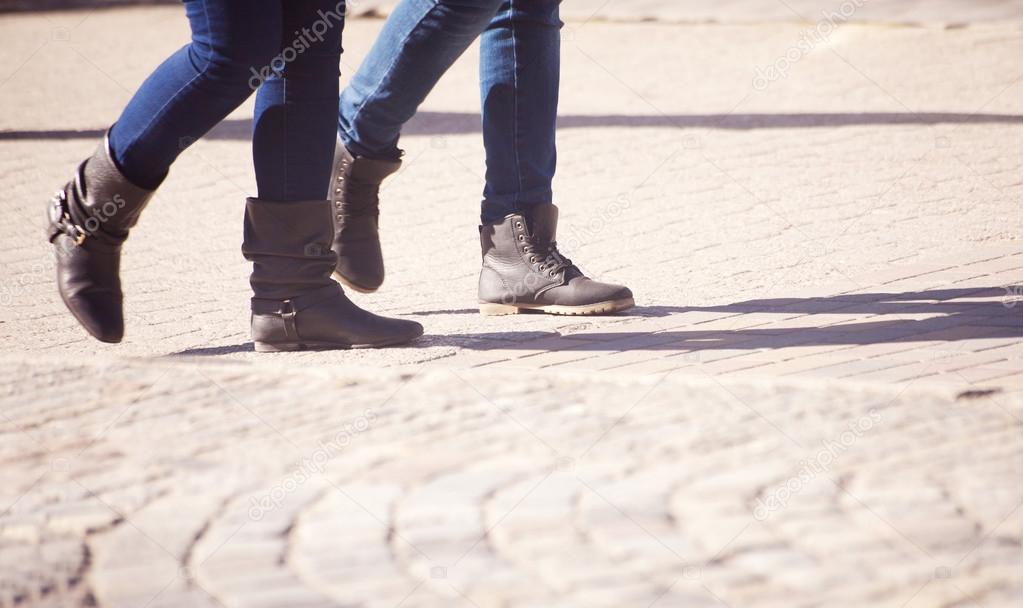 pedestrians legs walking on the sidewalk