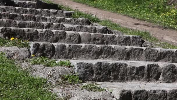 Piernas femeninas bajando las escaleras de piedra — Vídeo de stock