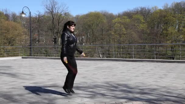 Jeune belle femme saut à la corde dans un parc de la ville — Video