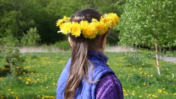 Flicka i en krans från maskrosor svängar och leenden — Stockvideo