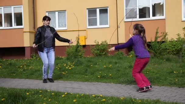 Maman avec sa fille sautant avec des cordes — Video