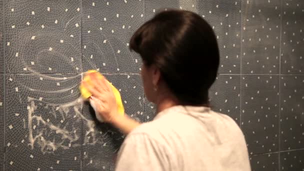 Woman washing the tile on the wall with a cloth lather — Stock Video