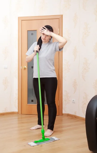 Young woman washes floor with a mop — Stock Photo, Image