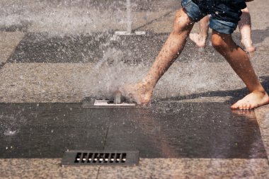 çocuğun ayak Mavi Jeans fıskiyede oynamak