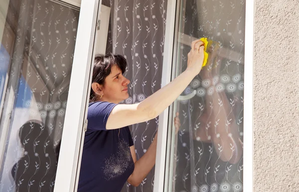 Mujer lava un cristal de la ventana —  Fotos de Stock
