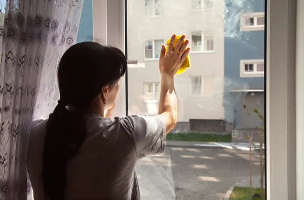 Mujer joven lavando la ventana — Foto de Stock