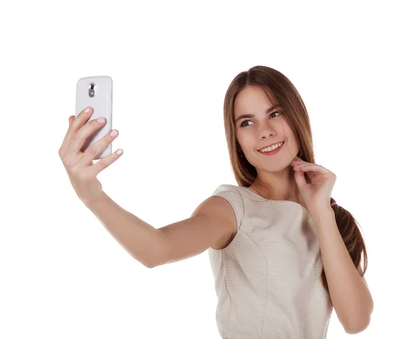 Молодая девушка фотографирует себя с помощью мобильного телефона — стоковое фото
