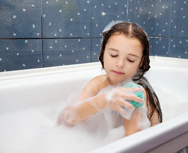 Tjej tvättar sin hand sitter i badet Stockbild