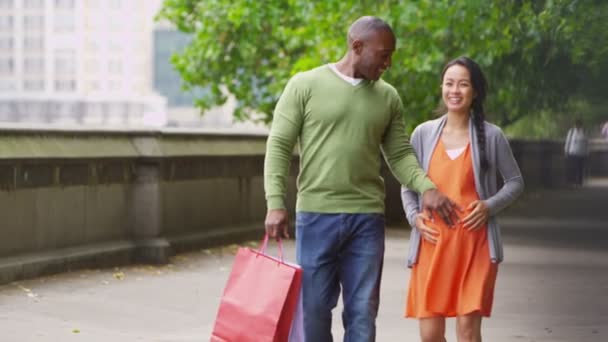 Pareja caminando con bolsas de compras en la ciudad — Vídeos de Stock