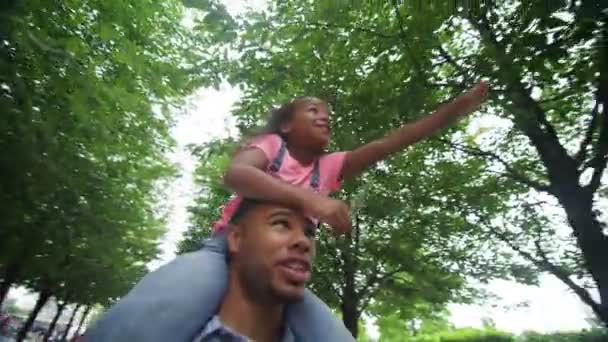 Батько і дочка гуляють у міському парку — стокове відео
